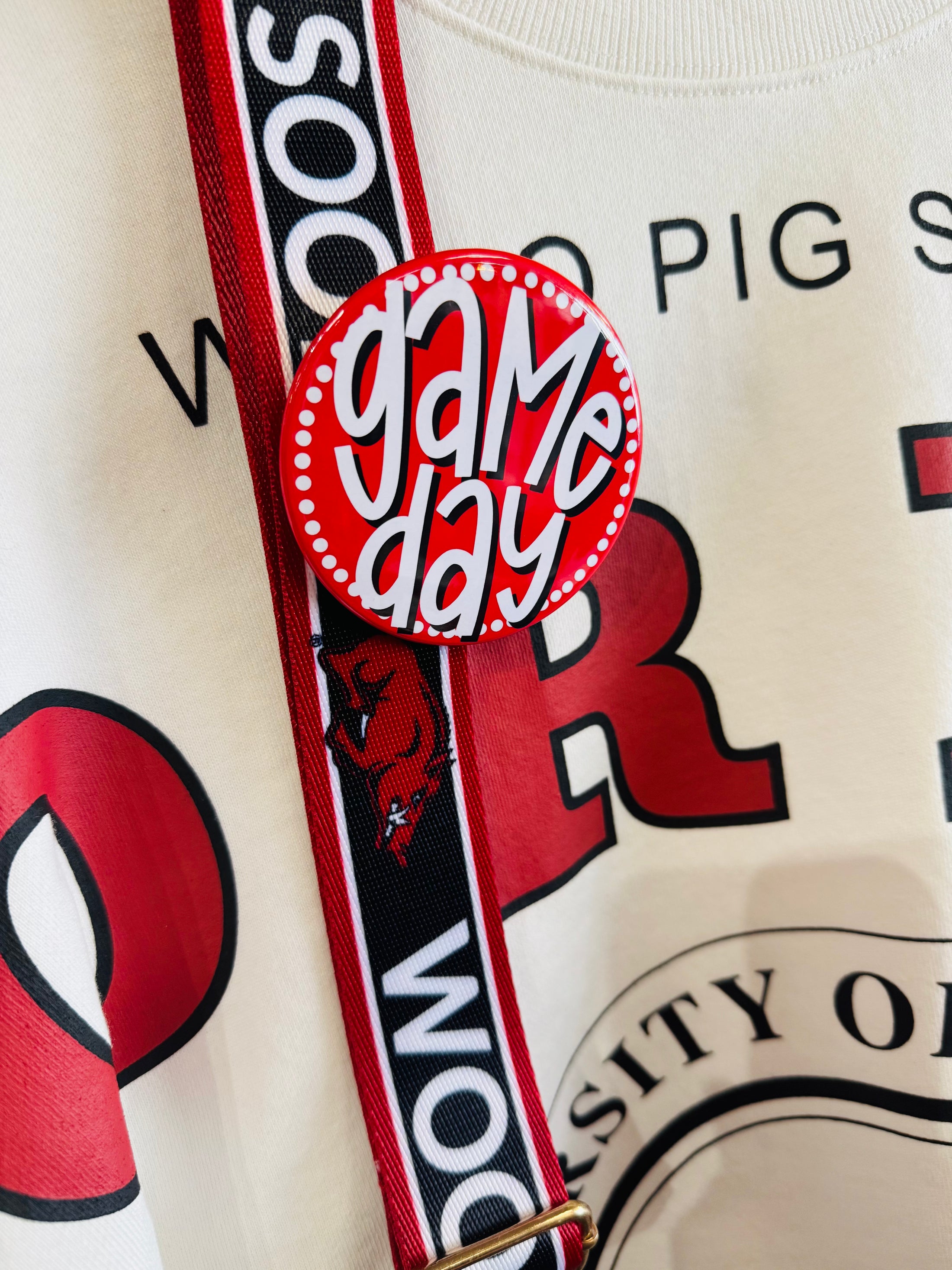 Circular sign with 'gameday' text in red and black on a white background