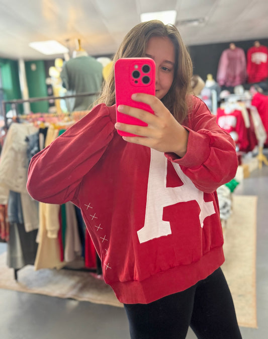 Person wearing a red sweatshirt with a large white letter 'A' in a Fayetteville, AR clothing store., arkansas sweatshirt, A sweatshirt, Arkansas Razorback sweatshirt for women, arkansas razorback store, arkansas razorback stores