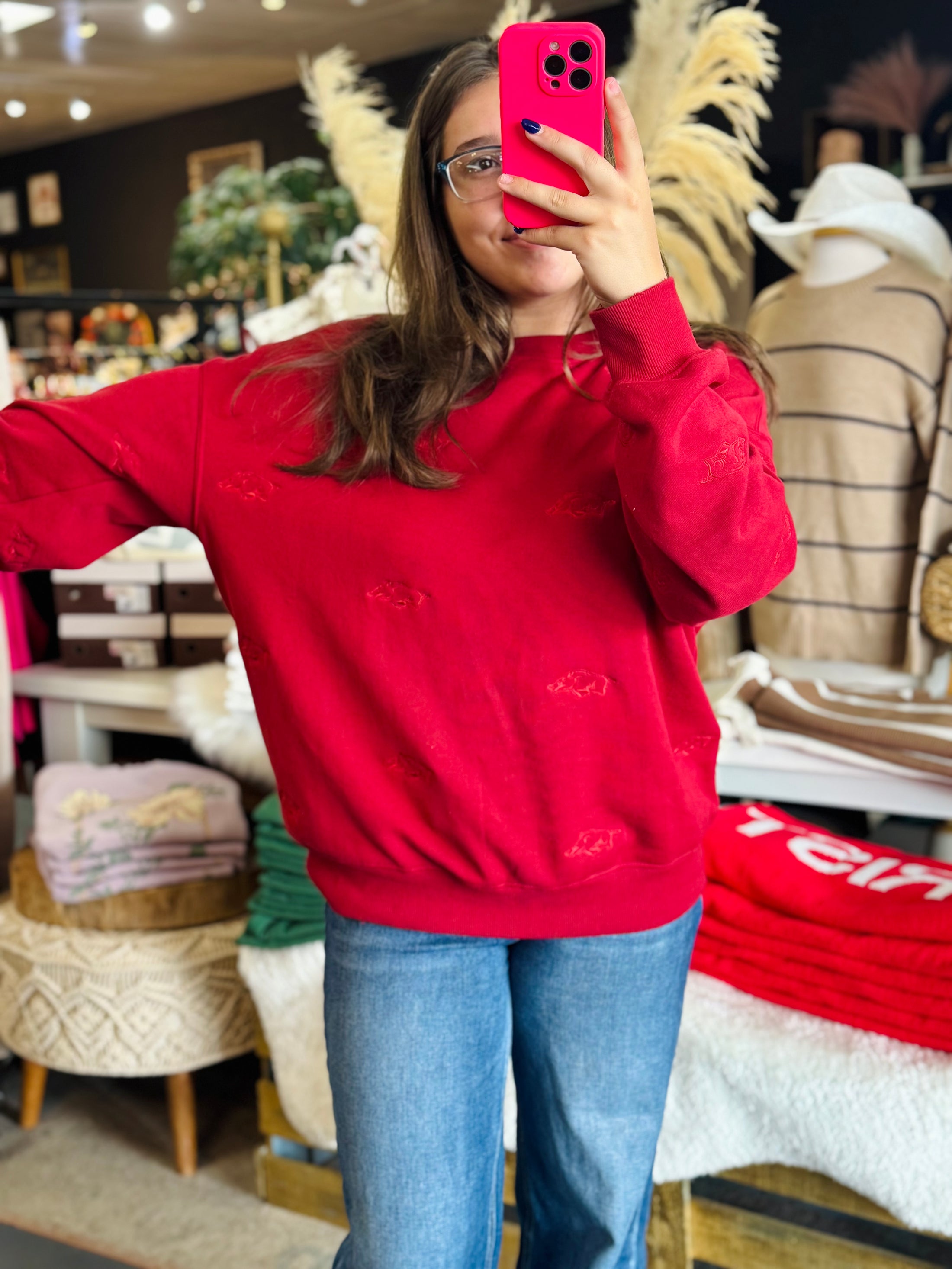 woman wearing red Arkansas Razorback sweatshirt in whimsy Whoo boutique store in their Whoo pig arkansas razorback store, white Arkansas Razorback tshirt, arkansas razorback shirt women, white arkansas razorback shirt women, Arkansas Razorback stores