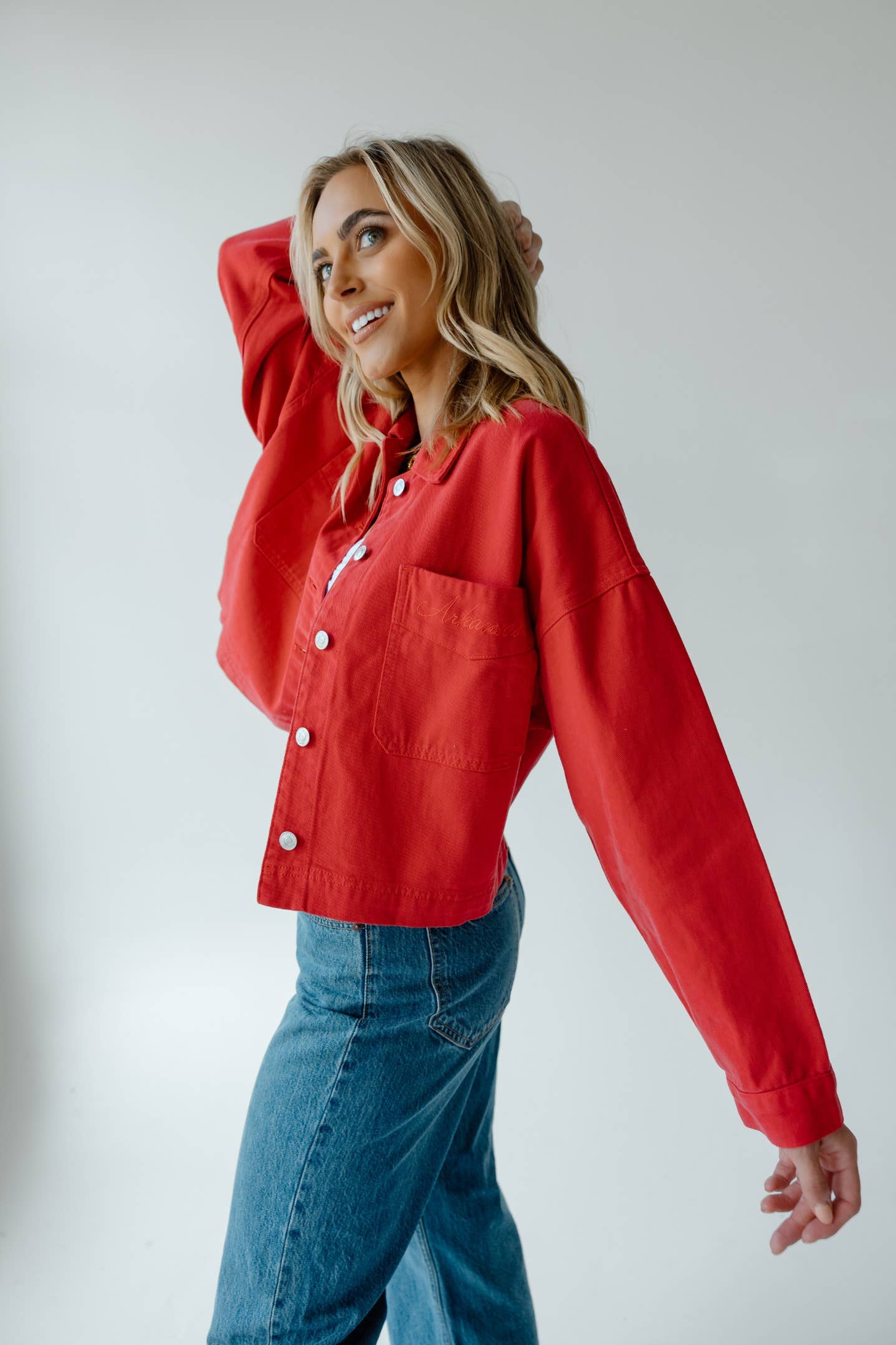 Woman wearing a red arkansas razorback jacket and blue jeans in a store in Fayetteville Arkansas, Arkansas razorback store, shopping Fayetteville Arkansas, razorback boutique apparel