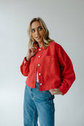 Load image into Gallery viewer, Woman wearing a red Arkansas Razorback jacket and women’s jeans in a Fayetteville, Arkansas boutique store, Arkansas razorback store, shopping in Fayetteville, arkansas

