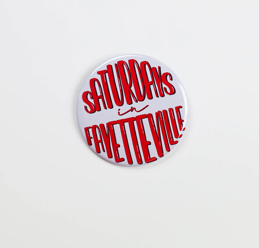 Button and gameday pin with 'Saturdays in Fayetteville' text in red on a white background, Razorback gameday pins, Arkansas gameday pins, Saturdays in Fayetteville gameday pin, Saturdays in Fayetteville gameday button, shopping in Fayetteville ar