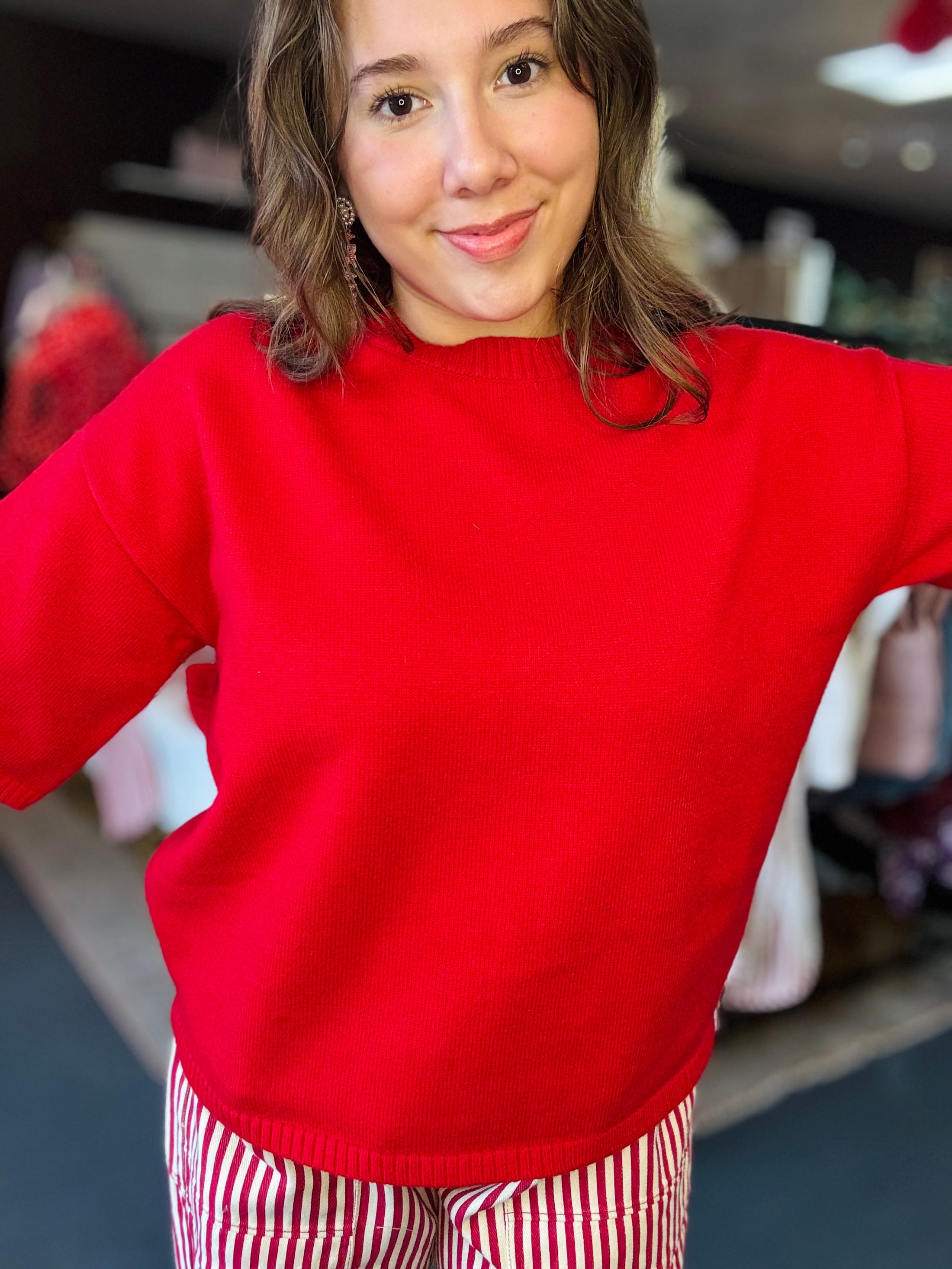 Person wearing a red sweater perfect for Razorback Gamedays in a Fayetteville Arkansas boutiques and Arkansas RAzorback store