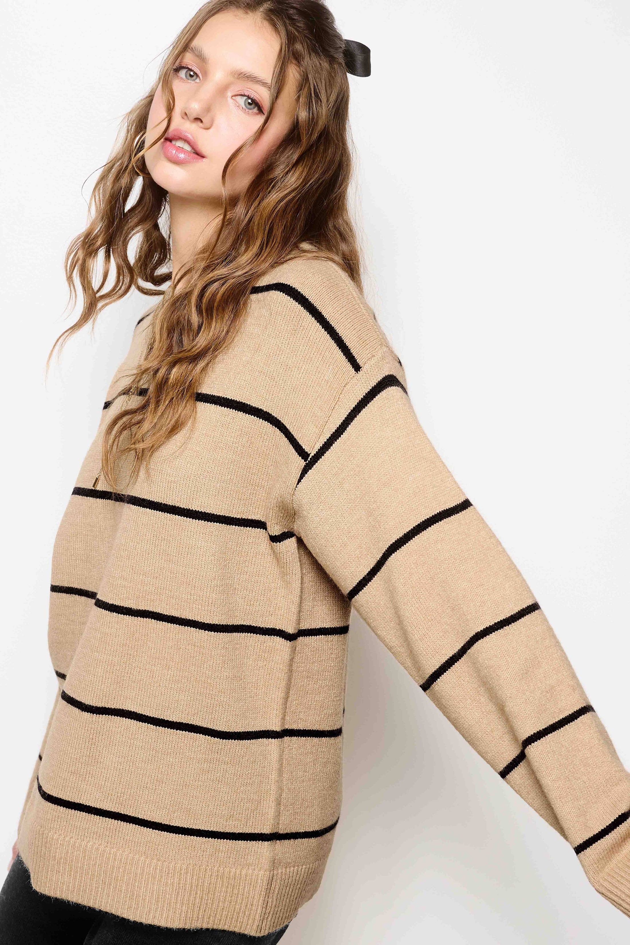 Woman wearing a beige sweater with black stripes on a white background, la miel sweater, la miel clothing, sweaters near me, Fayetteville ar clothing stores