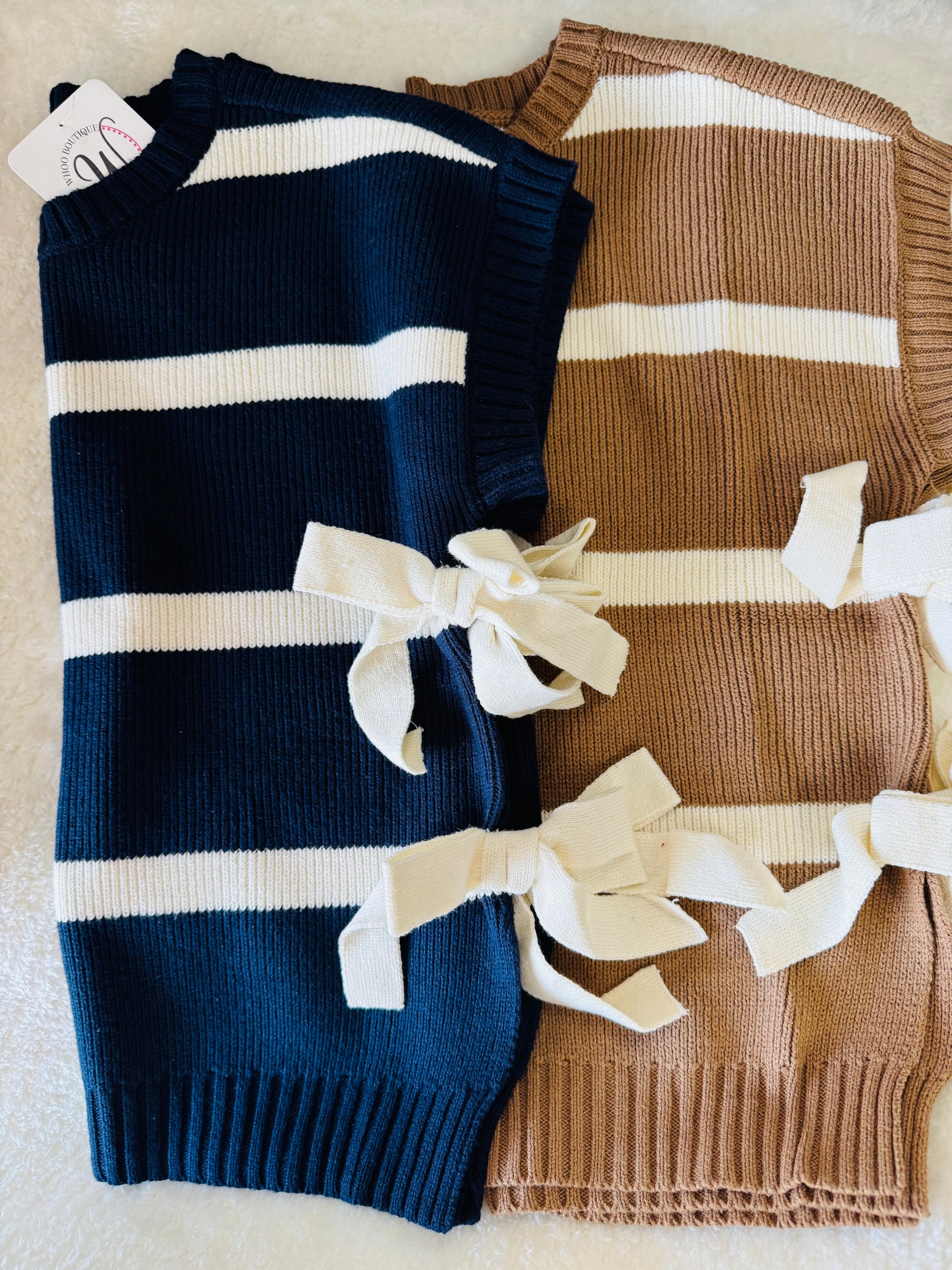 Two folded sweaters, one blue with white stripes and one brown with white stripes, on a light background. Striped sweater, sweater vest, blu pepper clothing, blu pepper sweater, sweater women, striped sweater vest, store near me fayetteville mall, boutique near me