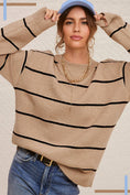 Load image into Gallery viewer, Woman wearing a beige sweater with black stripes and blue jeans against a neutral background, casual striped sweater for women, clothing stores Fayetteville ar
