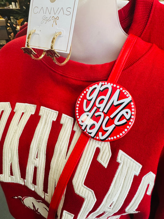 Red sweatshirt with white text and a 'Game Day' pin, displayed on a mannequin.