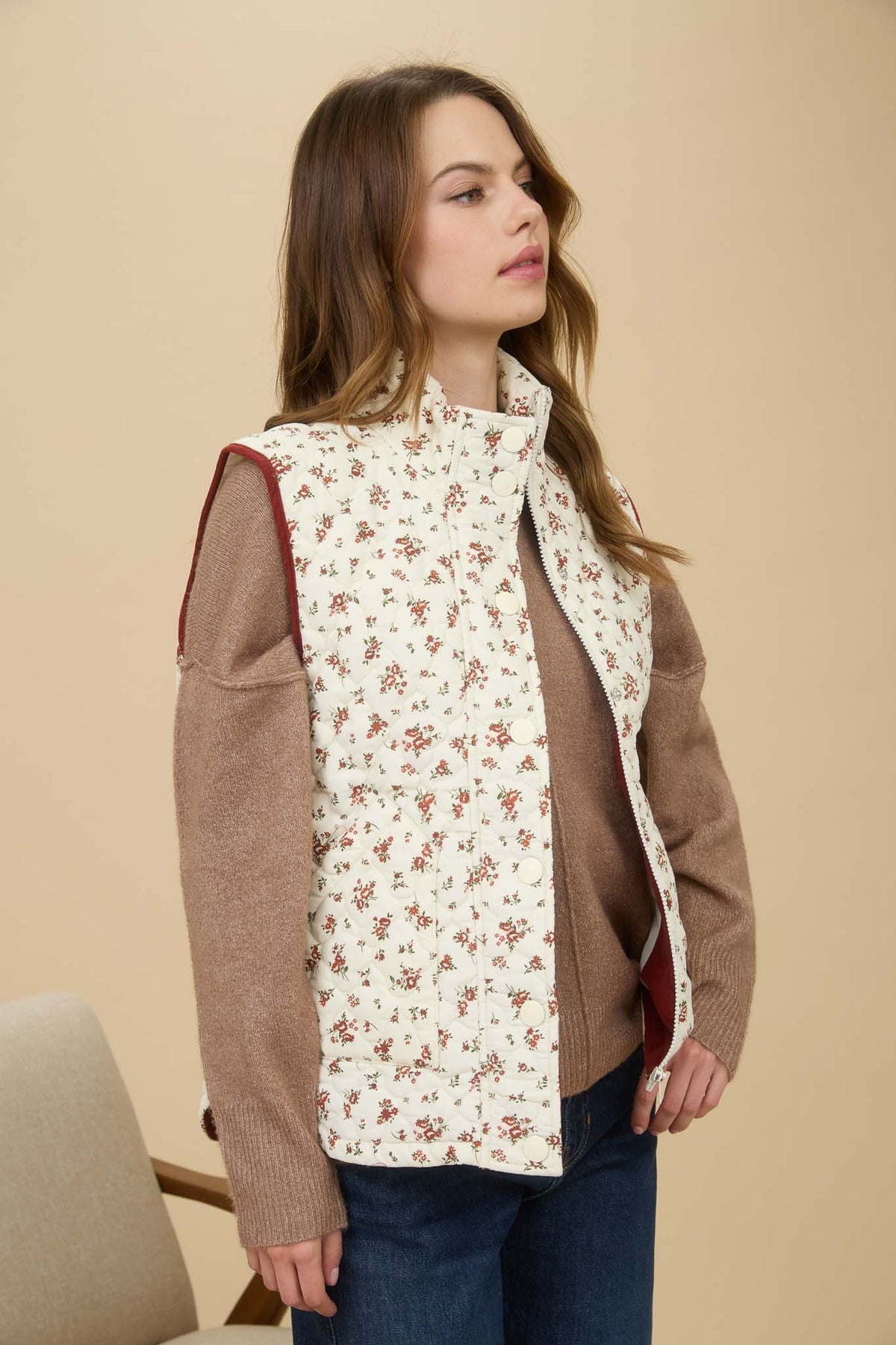 Woman wearing a brown jacket with a floral patterned inner lining against a beige background Floral vest, floral vest zara, floral vest top, floral vest puffer, floral vest women’s, vintage floral vest
