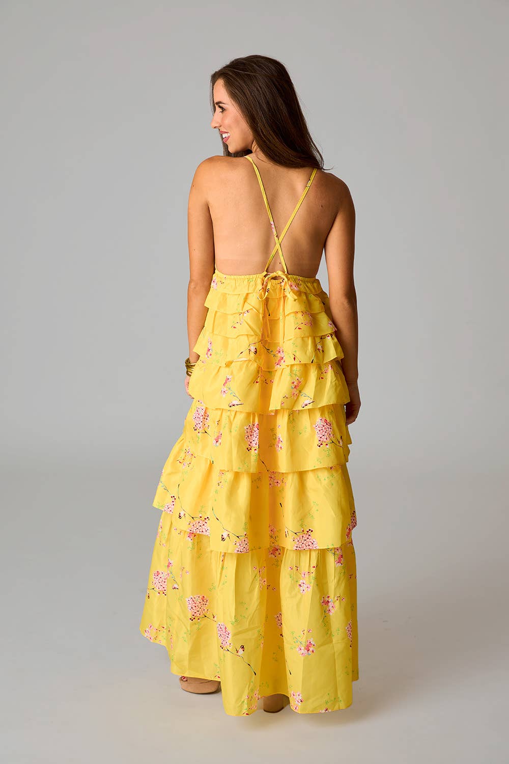 Woman wearing a yellow floral dress from a Fayetteville, ar boutique.