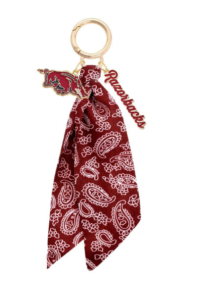 Red bandana keychain with gold ring and 'Rumpl' branding on a white background