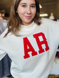 Load image into Gallery viewer, A smiling model wearing the AR mock neck sweatshirt, highlighting the boutique fashion available at our clothing store near the Fayetteville Mall.
