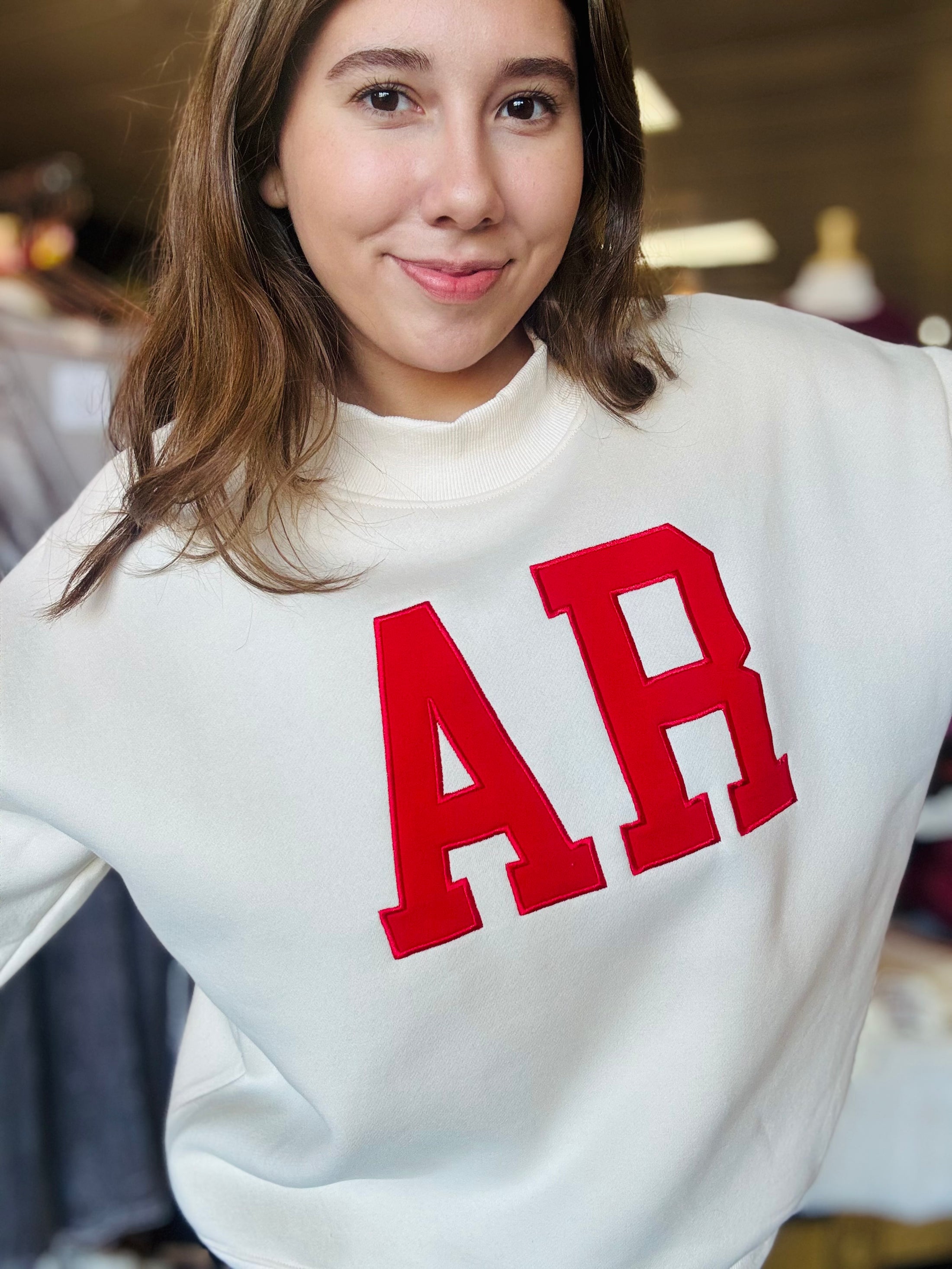 A smiling model wearing the AR mock neck sweatshirt, highlighting the boutique fashion available at our clothing store near the Fayetteville Mall.