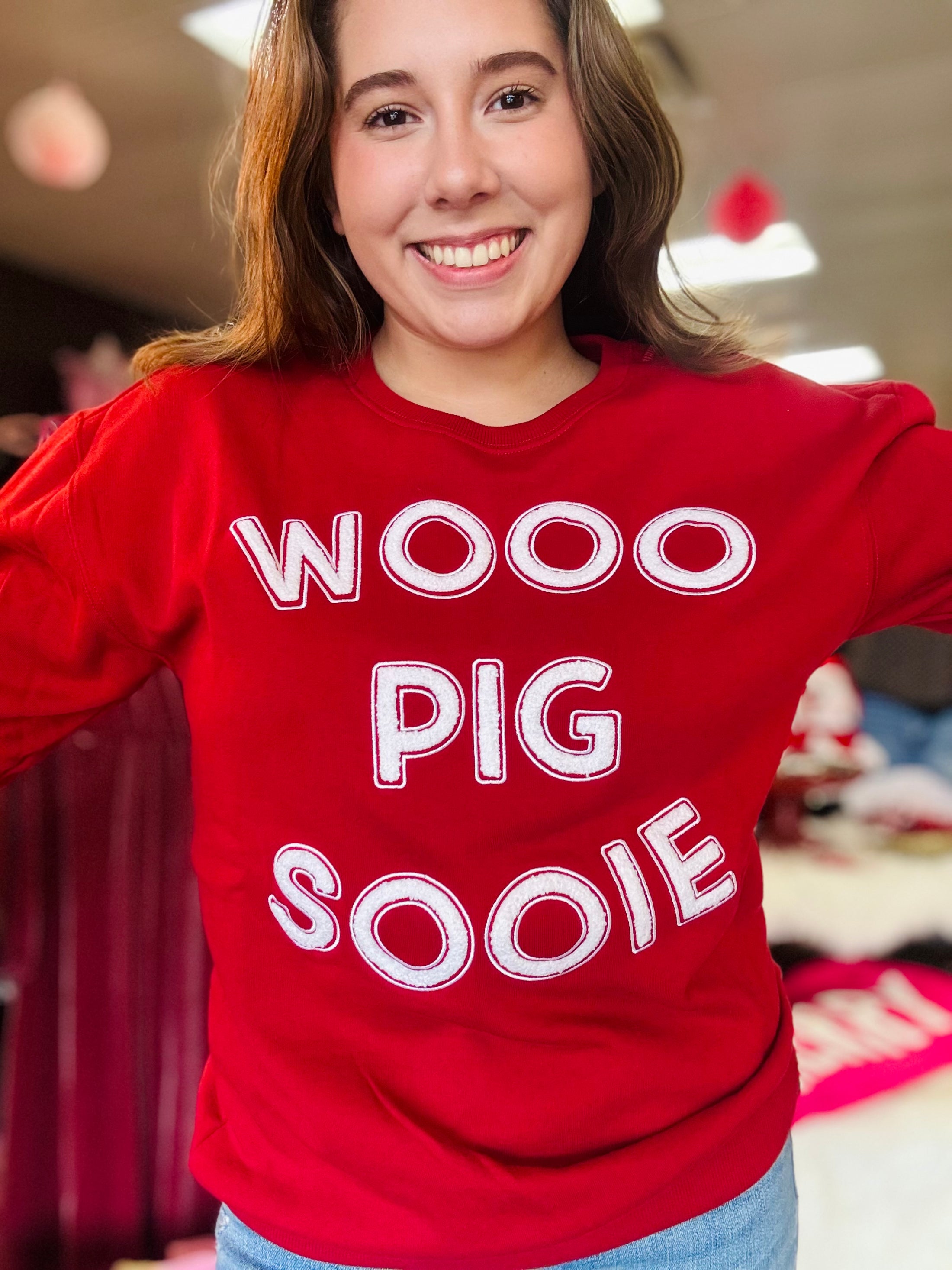 A full portrait shot of the Wooo Pig Sooie red sweatshirt, the perfect spirit piece for repping the Hogs at Baum-Walker Stadium or the Fayetteville Square.