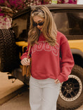 Load image into Gallery viewer, Woman wearing the Chic Spot Hogs Polka Dot Arkansas Sweatshirt with white jeans and a tan bag in Fayetteville.

