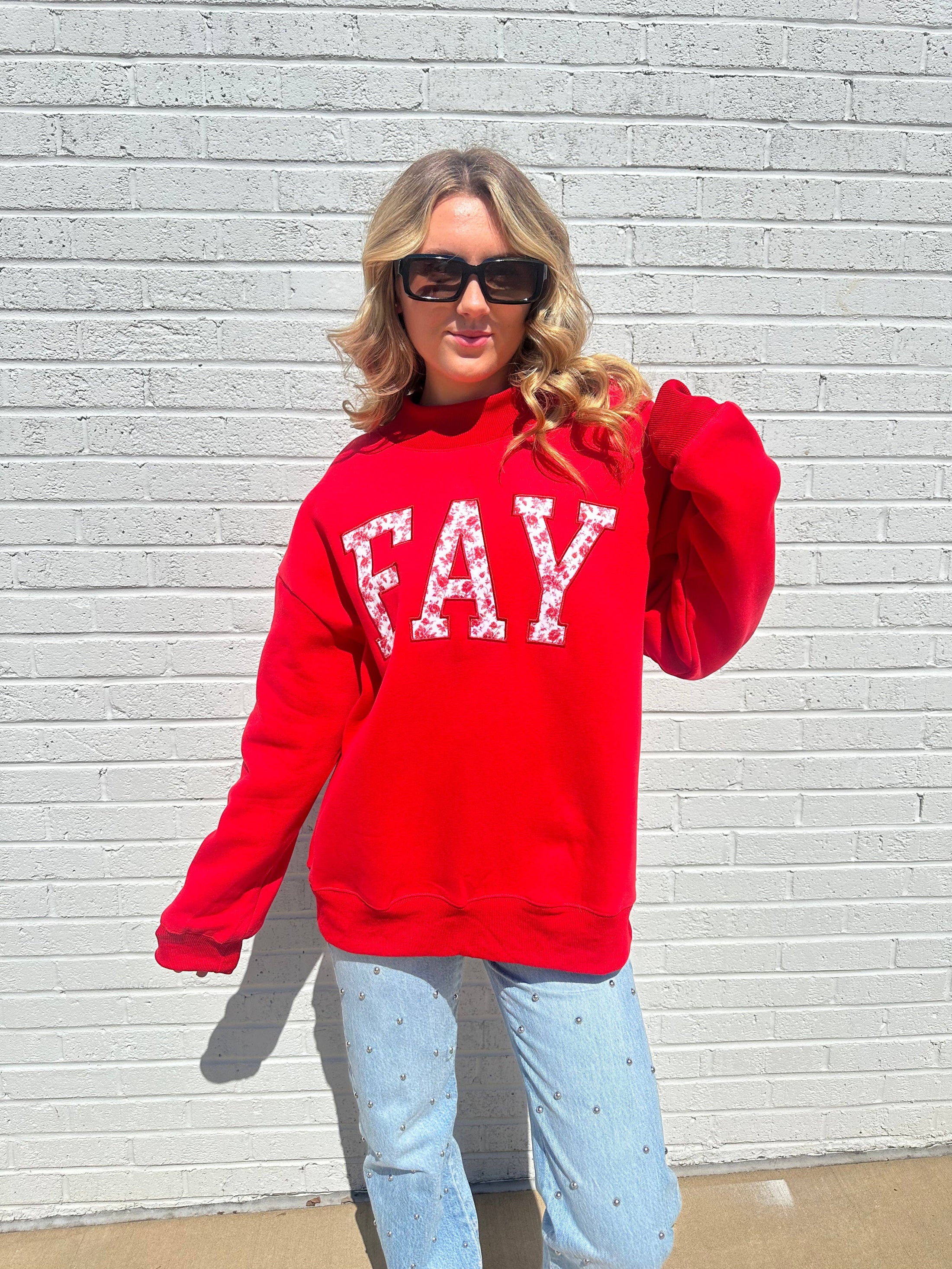 Front view of the trendy red Arkansas mock neck sweatshirt featuring white "FAY" text, a must-have piece for Fayetteville gameday fashion.