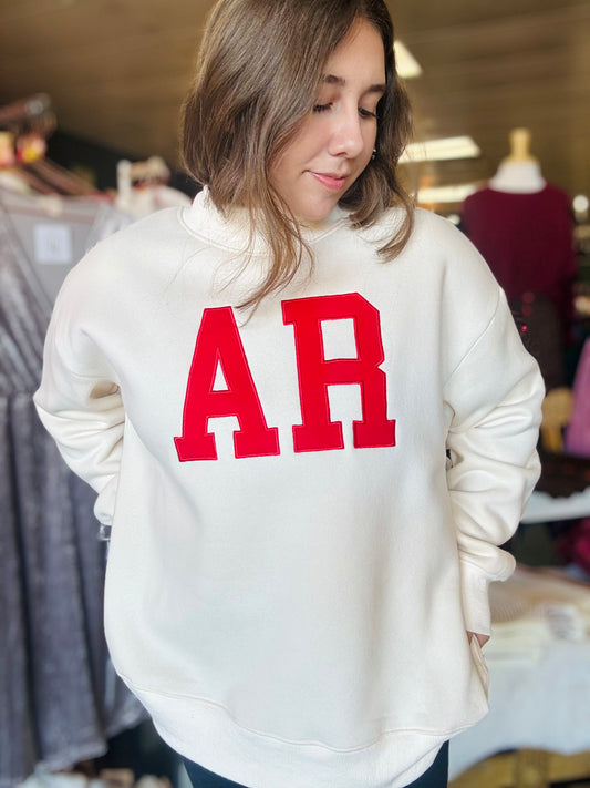 Model showcasing the oversized cream sweatshirt with red AR embroidery, perfect for gameday at a top boutique in Arkansas.