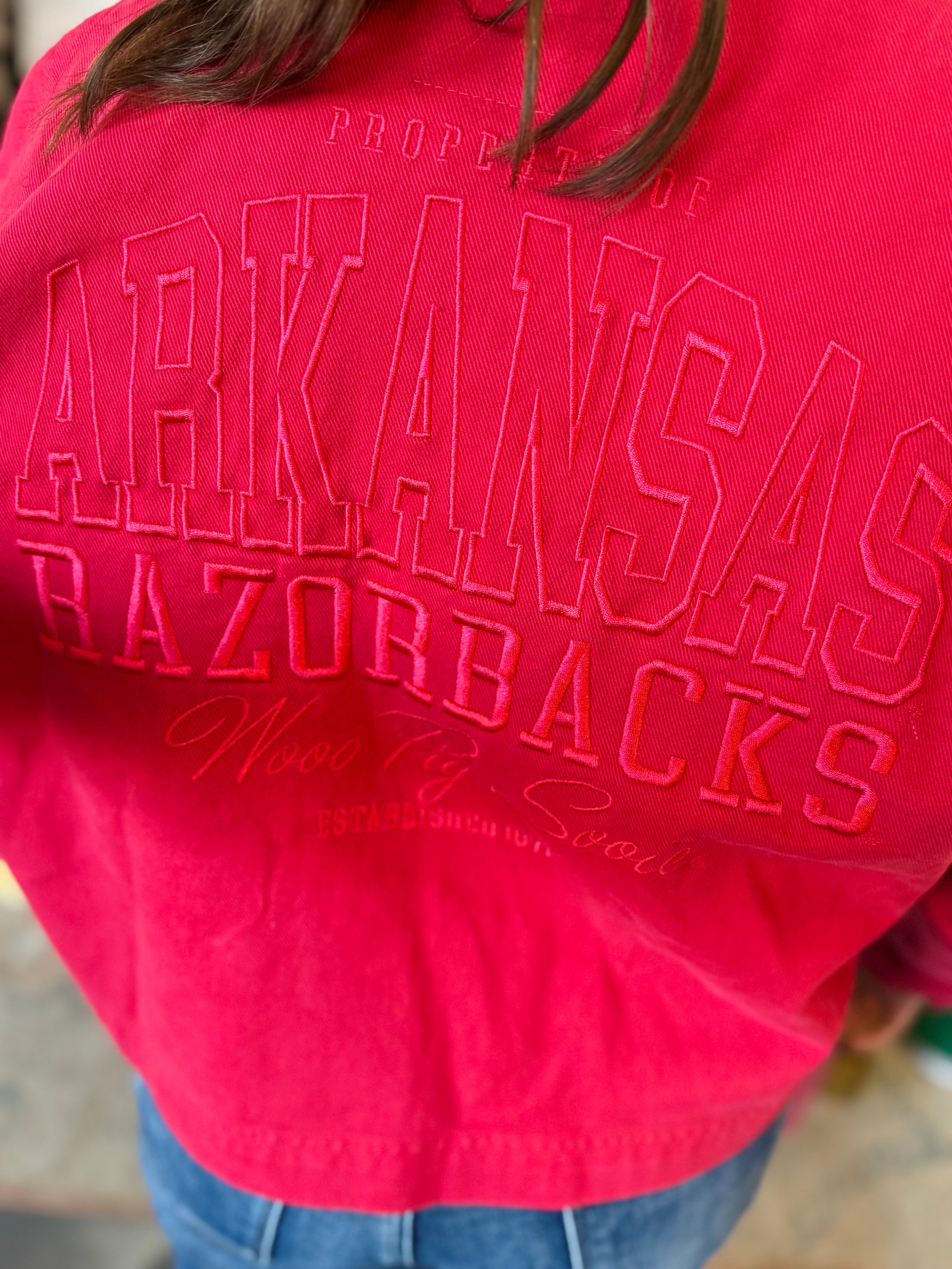 Close-up of the high-quality tonal embroidery on the back of the Charming Stitch jacket featuring "Arkansas Razorbacks" and "Wooo Pig Sooie" script for premium gameday apparel.