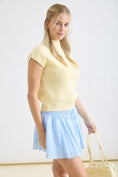 Load image into Gallery viewer, Detailed side profile of a cream ribbed knit top with a mock neck and cap sleeves. Available at Whimsy Boutique, your favorite Arkansas boutique for trending spring styles.
