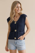 Load image into Gallery viewer, Close-up of a woman with her hand in the pocket of the Life is Golden Button Down Knit Vest, highlighting the chunky ribbed texture and high-shine gold buttons.
