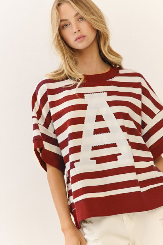 A cardinal and white striped short-sleeve sweatshirt featuring a white varsity 'A' appliqué, a best-selling gameday style at Whimsy Whoo in Fayetteville."