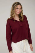 Load image into Gallery viewer, A woman wearing the Burgundy Comfy-Classic Ribbed Polo from Whimsy Boutique, a premier Arkansas boutique. This long sleeve textured knit features a relaxed fit and raw-edge hem, perfect for those looking for a boutique in Fayetteville.
