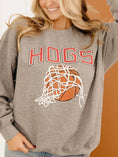 Load image into Gallery viewer, A woman smiling in the Nothing But Net Hogs Sweatshirt. This soft 50/50 cotton-poly blend crewneck is a must-have for the Arkansas basketball season.
