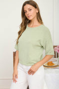 Load image into Gallery viewer, Side detail of the Meet Me in the Meadow Box Knit Sweater in sage green. Highlighting the raw-edge sleeve and drop shoulder design at Whimsy Boutique, your premier Arkansas boutique.

