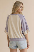 Load image into Gallery viewer, The back view of the Lavender Lane Oversized Top at Whimsy Boutique, highlighting the trendy reverse overlock out-seam stitching and comfortable waffle-textured knit.
