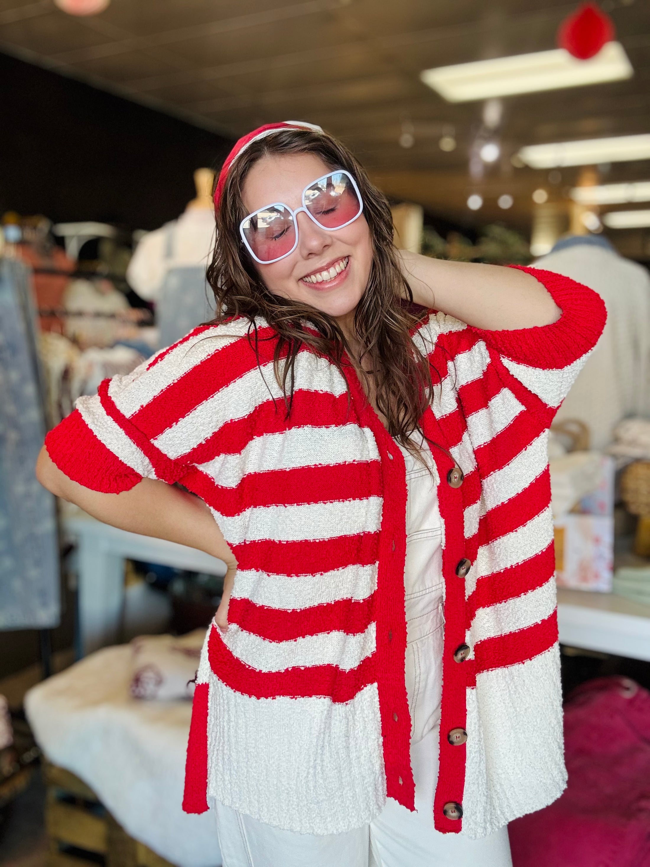 An angled shot of the red and white striped oversized cardigan, perfect for spring transition and repping the Hogs at Whimsy Whoo Boutique.