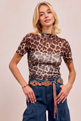 Load image into Gallery viewer, A blonde model wearing the Wild Side Mesh Mock Neck leopard print top, a versatile layering piece from Whimsy Whoo in Fayetteville.
