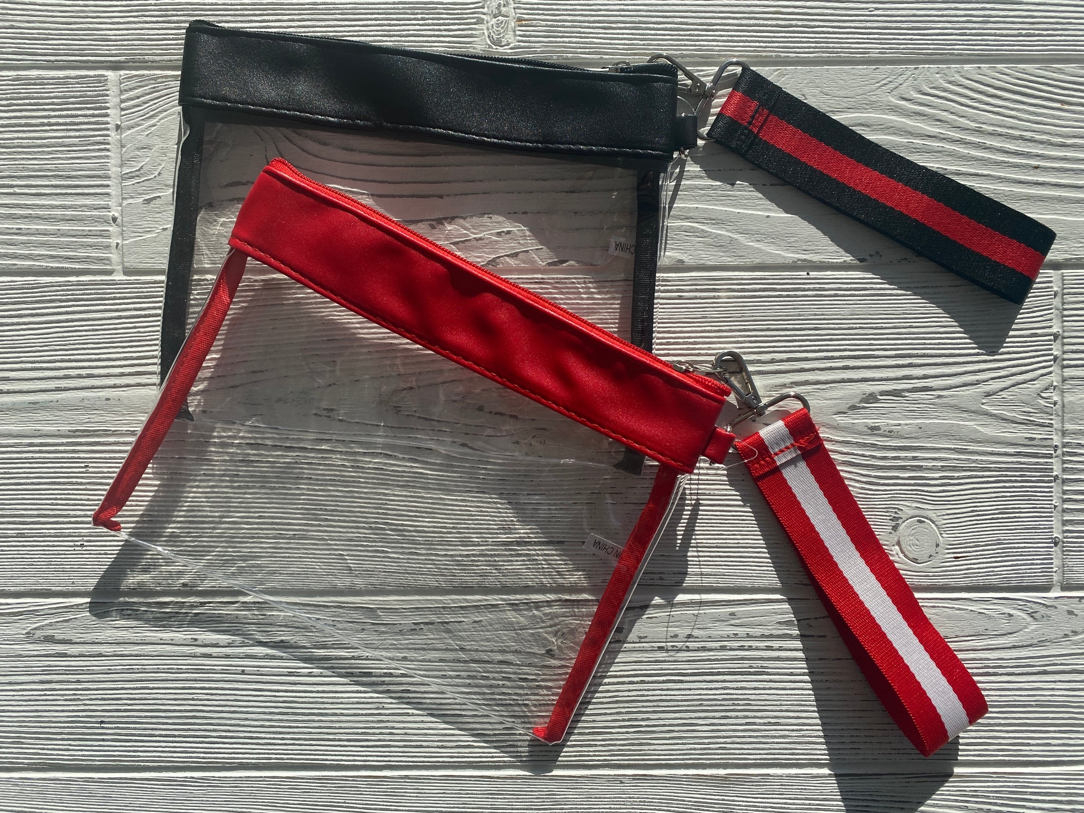 Grab & Go clear vinyl wristlet with a vibrant Razorback red and white patterned strap, perfect for Arkansas gameday.